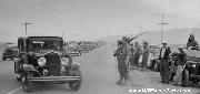 MP Jeeps watch as a caravan of evacuees of Japanese ancestry enter an undisclosed Internment Camp somewhere in California in 1942.